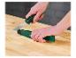 Hände halten ein Messer mit grün-schwarzem Griff und eine grüne Scheide auf einem Holztisch.
