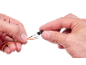Hände halten Kabel mit gecrimpten Anschlüssen und einen schwarzen Kunststoffstecker.