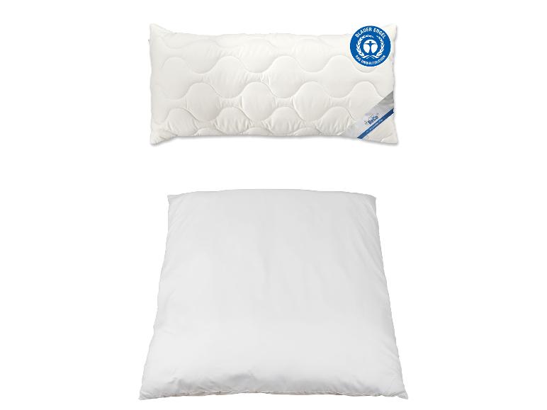 Zwei weiße Kissen, eines gesteppt mit Blauer Engel-Etikett, das andere schlicht.