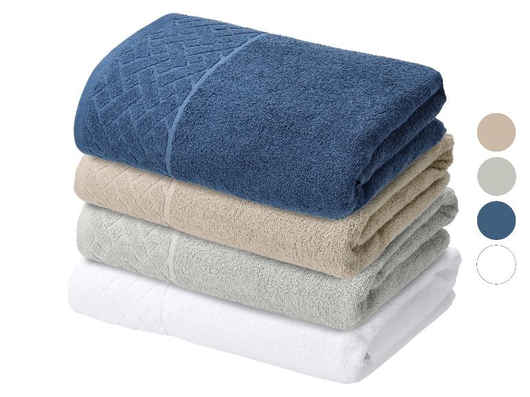 Stapel von vier Handtüchern in Blau, Beige, Grau und Weiß.