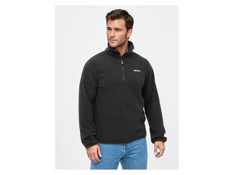 Mann in schwarzem Bench. Fleece-Pullover und blauen Jeans.