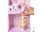 Kinderhand spielt mit einem rosa Holzpuppenhaus, mit Möbeln und Wendeltreppe.