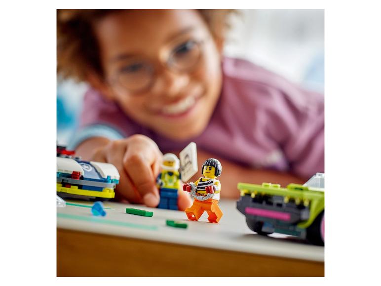 Ein lächelndes Kind spielt mit LEGO-Figuren und Autos.