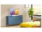 Fernseher auf einem blauen Sideboard in einem hellen Schlafzimmer mit Stadtblick.