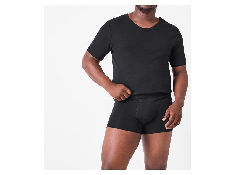 Mann in schwarzem V-Ausschnitt-T-Shirt und schwarzen Boxershorts.