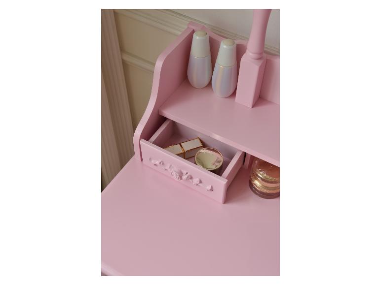 Rosa Schminktisch mit offener Schublade, Kosmetik und dekorativen Flaschen.