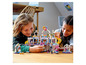 Zwei Kinder spielen mit einem LEGO Friends Einkaufszentrum mit Rutsche und Karussell.