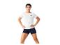 Frau in weißem T-Shirt und dunkelblauen Shorts, Hände in den Hüften.