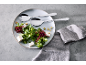 Salatbesteck auf einem Teller mit frischem Salat, Feta und Croutons.