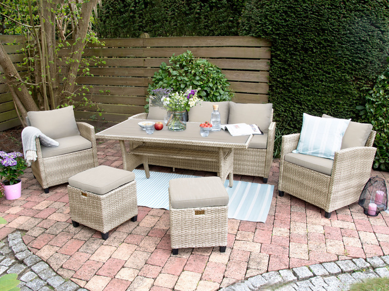 Gartenmöbel aus Weide mit Tisch und Stühlen auf einer gepflasterten Terrasse.