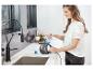 Frau füllt einen Bissell Steam Shot Dampfreiniger mit Wasser in einer Küche.