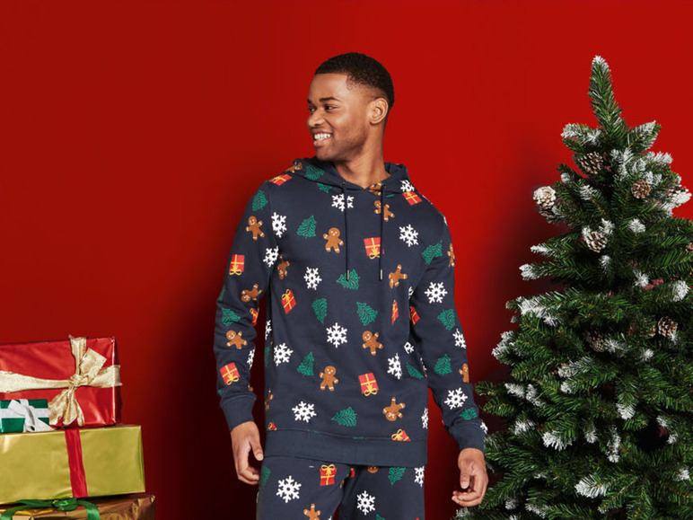 Mann trägt einen Weihnachtspullover und -hose mit Lebkuchenmuster.