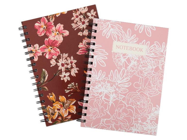 Zwei Spiralnotizbücher mit Blumenmustern, eines braun, das andere rosa mit der Aufschrift „NOTEBOOK“.