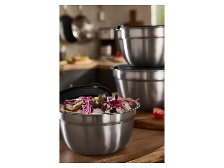 Edelstahl-Rührschüsseln mit Deckeln, eine gefüllt mit Salat, in einer Küche.