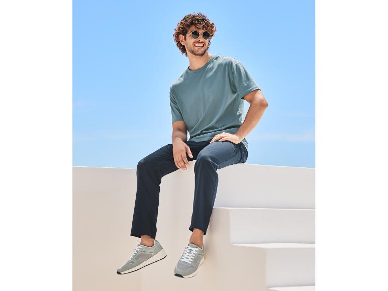 Lässiges Herren-Outfit: T-Shirt, Hose und Sneaker.