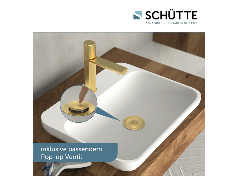 Eine goldene Armatur mit einem Pop-up-Ablauf in einem weißen Waschbecken.