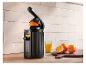 Schwarze SilverCrest Saftpresse, Glas Orangensaft und Orangen auf Holzschneidebrett.