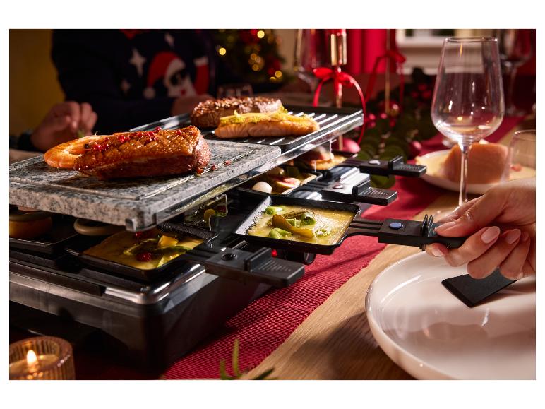 Raclette mit gegrilltem Fleisch und Meeresfrüchten, geschmolzenem Käse und Gemüse.