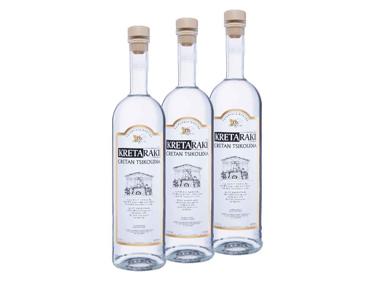 Drei Flaschen klaren kretischen Schnaps mit weißen und goldenen Etiketten.