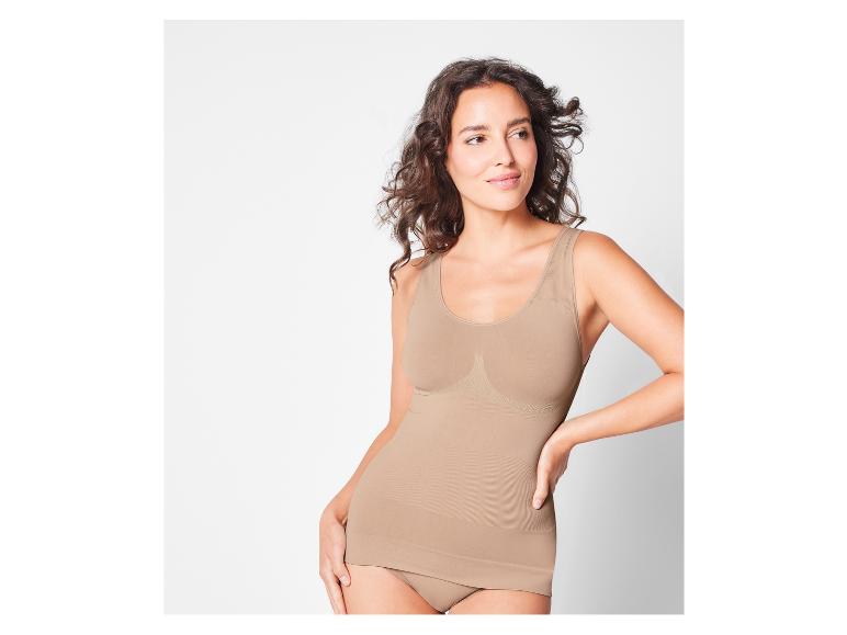 Eine Frau trägt ein beiges, nahtloses Top und Unterwäsche.