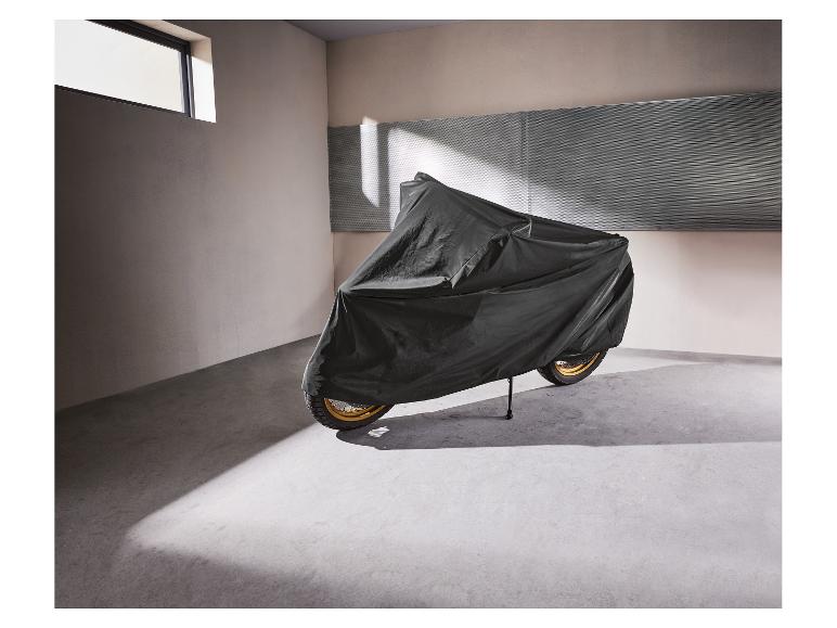 Motorrad mit schwarzer Schutzhülle in einer Garage.