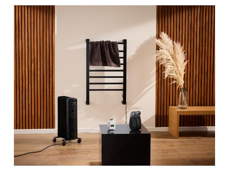 Schwarzer Ölradiator und Handtuchwärmer in einem modernen Raum.