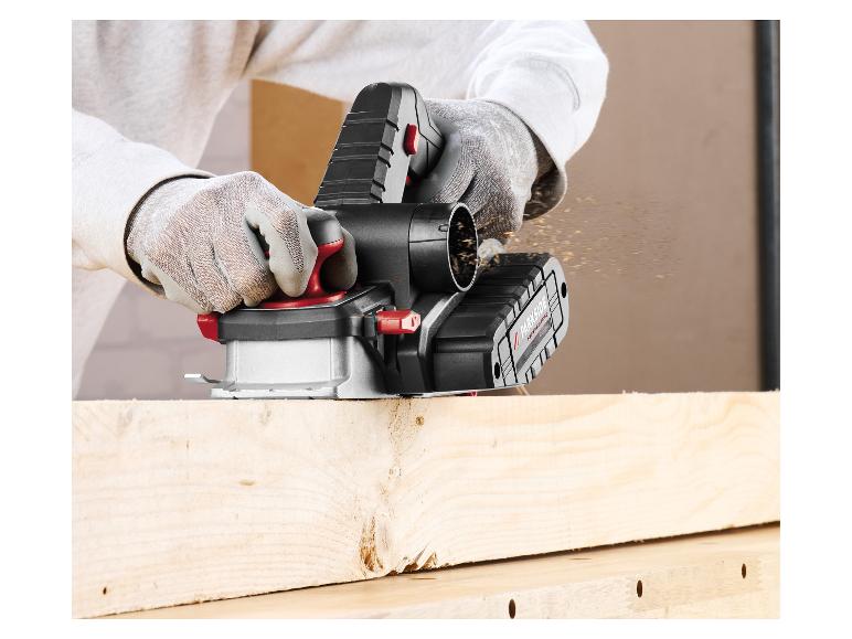 Akku-Elektrohobel in Aktion, mit Holzspänen, die von einem Holzbrett fliegen.