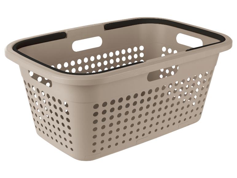 Ein beigefarbener Wäschekorb mit schwarzen Griffen.
