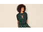 Frau in einem grünen Weihnachts-Sweatshirt mit Lebkuchenmann-Print und passender Hose