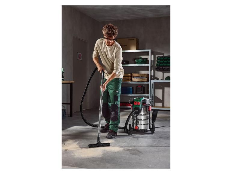Mann saugt einen Garagenboden mit einem Parkside Nass- und Trockensauger.