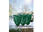 Drei grüne Pflanzenschutzhüllen in einer verschneiten Winterlandschaft.