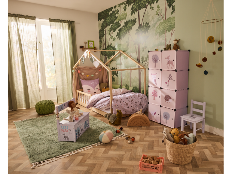 Kinderzimmer mit Hausbett, rosa Aufbewahrungsregalen und Teppich.