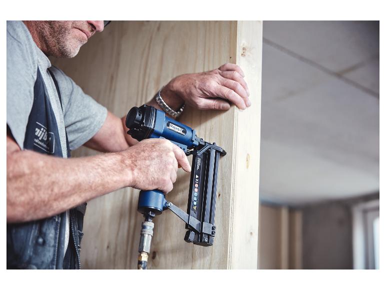 Mann verwendet einen Drucklufttacker/-nagler zum Befestigen von Holzpaneelen.