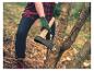 Person in Handschuhen und kariertem Hemd hackt Holz mit einer Axt.