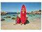 Rotes SUP-Board mit Paddel, Tasche und Pumpe an einem Sandstrand mit türkisfarbenem Wasser.