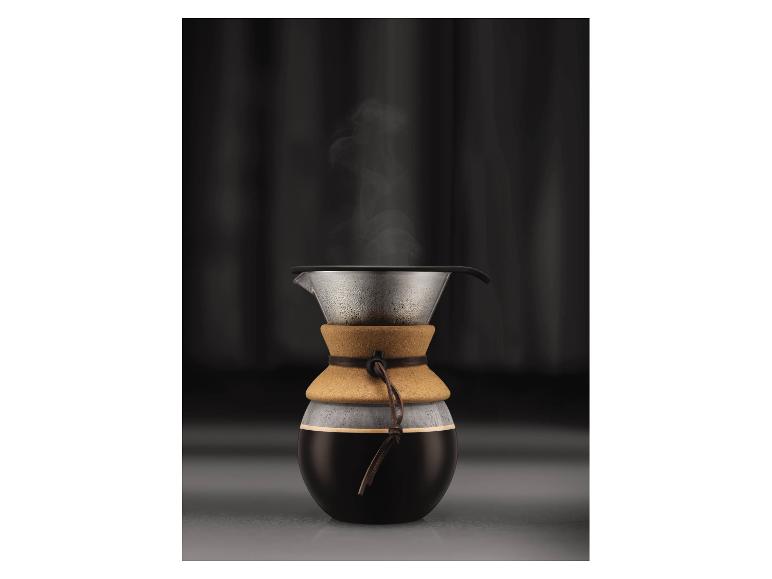 Glaskaffeemaschine mit Korkband und dampfendem Kaffee.