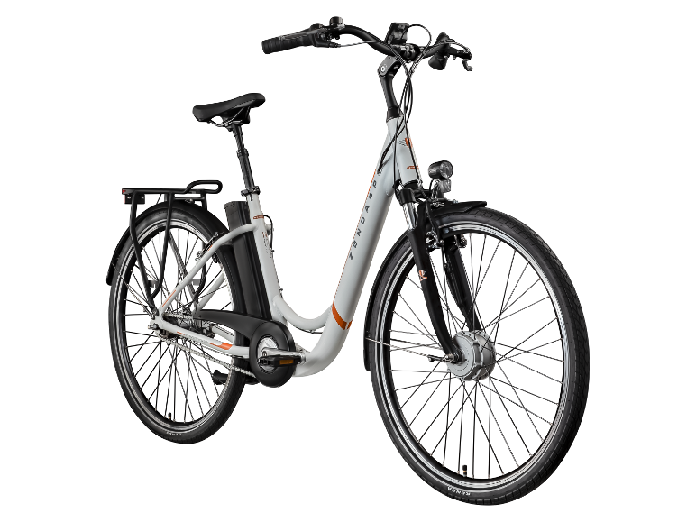 Weißes E-Bike mit orangefarbenen Akzenten, Gepäckträger sowie Vorder- und Rücklichtern.