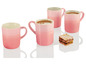Vier rosa Le Creuset Tassen mit Kaffee und Gebäck.