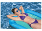 Eine Frau in einem Bikini liegt auf einem blauen aufblasbaren Floß in einem Pool.