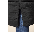 Detail einer schwarzen Steppjacke mit seitlichem Reißverschluss, über blauen Jeans getragen.