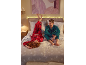 Mann und Frau in festlichen Karo-Pyjamas entspannen auf einem Bett mit Weihnachts-Bettwäsche.