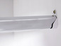 Eine verchromte Kleiderstange mit Halterung, die an einer weißen Wand befestigt ist.