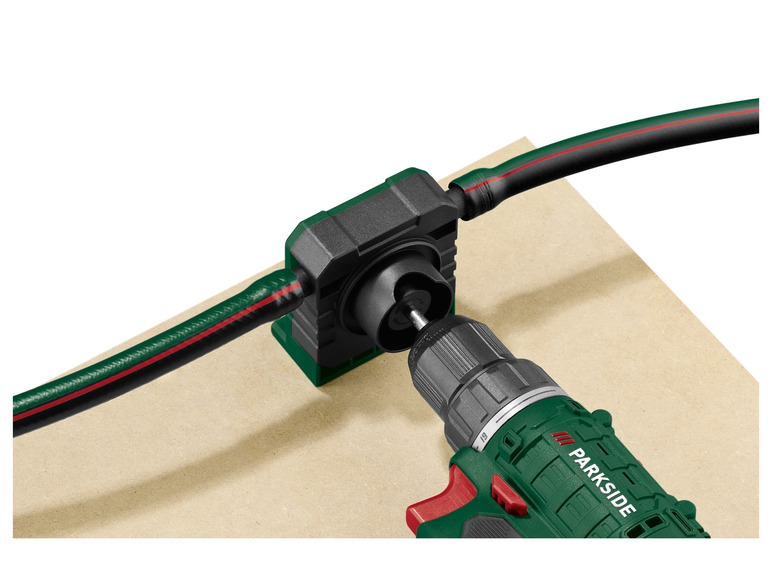 Eine grüne Parkside Bohrmaschine mit einer Lochfräse für einen Schlauch.