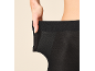 Frau dehnt den Bund einer schwarzen Strumpfhose, zeigt Elastizität.