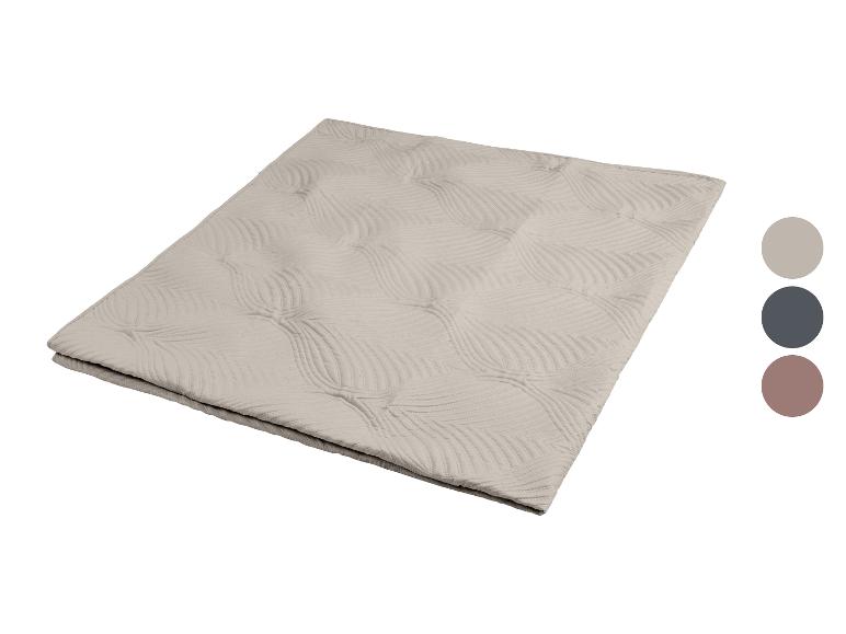 Beige Decke mit Blattmuster und drei Farbfeldern.