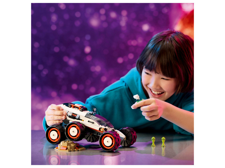 Ein Kind spielt mit einem LEGO-Fahrzeug und Außerirdischen.