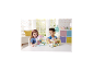 Zwei Kinder spielen mit einem Spielzeugschloss und einem Spielzeugbus voller Tierfiguren.