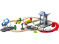 Spielzeug-Eisenbahn- und Auto-Set mit Bahnhof, Holzschienen und Straße.