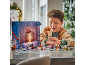 Ein Junge spielt mit einem Spielzeug-Adventskalender am Tisch.