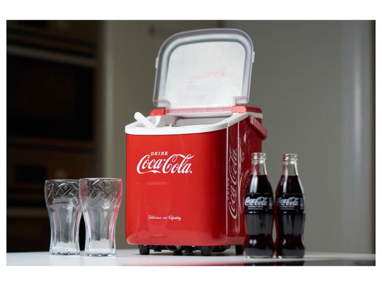Eine rote Coca-Cola Kühlbox mit zwei Flaschen Coca-Cola und zwei Gläsern.